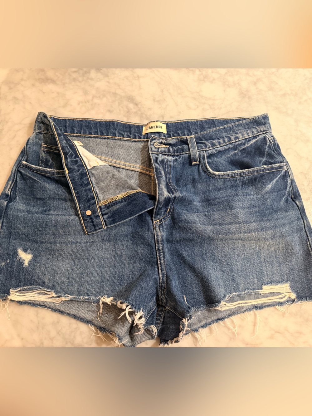 L'AGENCE Distressed Denim Cutoff Shorts in Blue